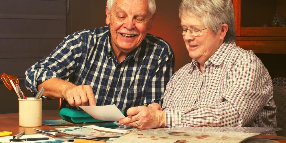 Older people looking at photos together as a fun relaxing activity to do together.