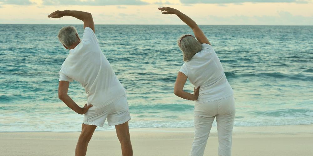 Seniors enjoying yoga on the beach