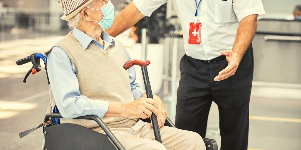 An elderly dementia patient receiving help from airport sfaff.